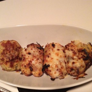 Baking the Red Potatoes 3 Large Red Potatoes 2 tbsp melted butter salt and pepper Coat potatoes in melted butter and salt and pepper evenly.  Wrap each potato individually in aluminum foil and bake on 450 degrees for 45 minutes. Once baked, allow to cool for about 15 minutes.  Cut each potato in half and remove insides of potatoes with a spoon and put in a medium size bowl.  Place halves back on baking sheet. Potato Stuffing Potato removed from halves 1/4 c milk 1/4 c Swiss cheese 1/4 c parmesan 1/4 c mozzarella 1/4 c bacon crumbs 1 tbsp butter In a medium mixing bowl that potatoes are already in, add butter, milk, mozzarella cheese, Swiss cheese, and salt and pepper.  Mix thoroughly and spoon back into halved red potatoes.  Once all potatoes have stuffing, sprinkle bread crumbs, parmesan, and bacon crumbles on top.  Bake on 375 for 20 minutes.  Broil for crispier top.