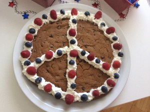  I must say, I am terrible at baking desserts, but this was a super easy to make cookie cake with a little patriotic flair.  1 roll pillsbury cookie dough blue berries raspberries whip cream Roll cookie dough into a large circle on a non-stick cookie sheet (I lined mine with parchment paper).  Bake on 350 for about 20-24 minutes.  *Since the directions on the cookie dough are for individual cookies, you have to cook the cookie cake longer because it is so much larger. Let cookie cake cool completely. Decorate with whip cream, raspberries, and blueberries.  I obviously made a peace sign, but the options are limitless. 